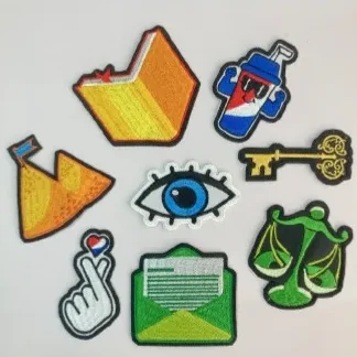 Fotografía de un método para hacer artículos promocionales: diferentes figuras bordadas hechas por Ink Soluciones.