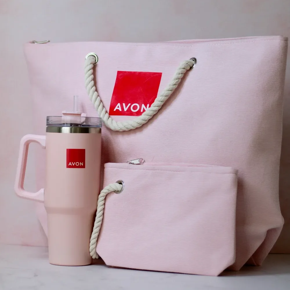 Artículos promocionales: fotografía de una bolsa grande, un neceser y un termo color rosa claro con estampado rojo.