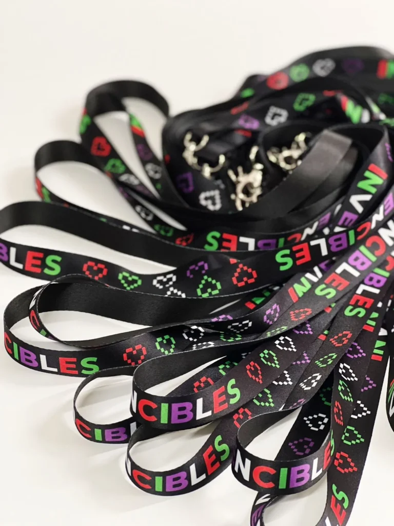 Portagafetes personalizados: fotografía de cintas en color negro con diseño en color rojo, morado, verde y blanco.