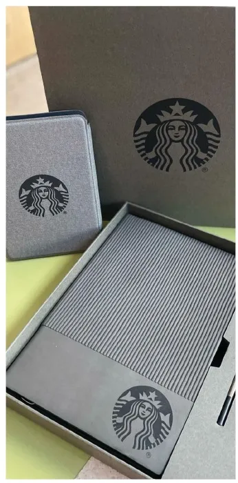 Fotografía de una de las carpetas personalizadas de una empresa en color gris con diseño minimalista y logotipo de la marca.