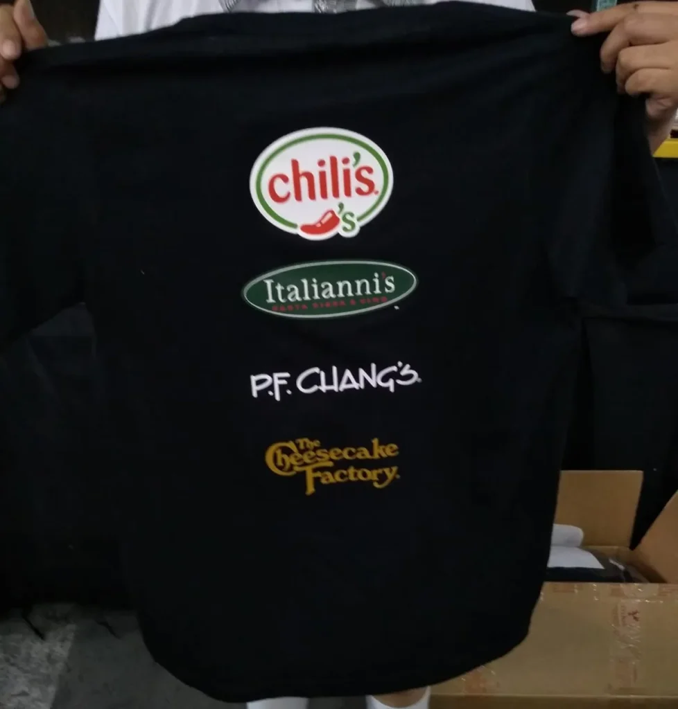 Fotografía de una persona sosteniendo una de las playeras personalizadas de la marca Ink Soluciones color negro.